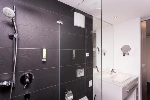 a bathroom with a shower and a sink at Grimm's Berlin Mitte in Berlin