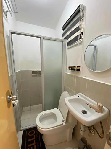 a bathroom with a toilet and a sink and a mirror at Olango Island - S&E-2 Tiny Guest House Fully Furnished with Hot Shower, Washer, Wi-Fi, Netflix & King-size Bed in Lapu Lapu City