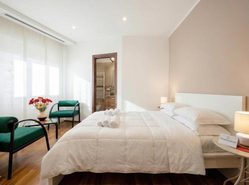 a white bedroom with a bed and a table and chairs at Bengasi Central Loft in Stazione Bari Centrale