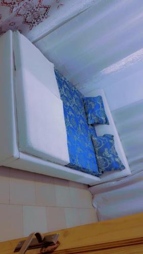 a white ceiling with blue and white pillows on it at A & A Apartments in Serekunda