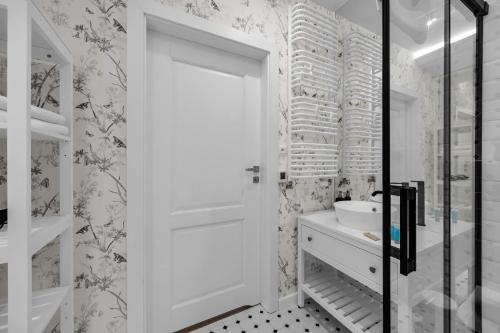 a bathroom with a white door and a sink at Mehoffera Superior Apartment by BookingHost in Warsaw
