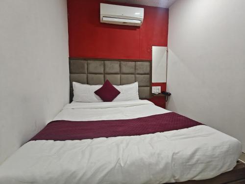 a bedroom with a large bed with a red wall at Hotel Silver Shine Jogeshwari in Mumbai