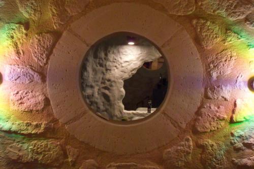 a round mirror in a stone wall with a tunnel at Troglodelice in Azay-le-Rideau