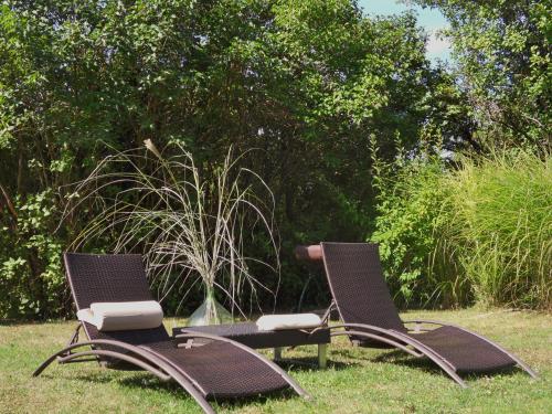 two chairs and a table sitting in the grass at Troglodelice in Azay-le-Rideau