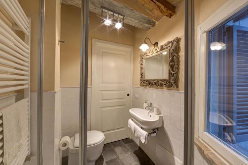 a bathroom with a toilet and a sink and a mirror at Le Stanze di Rigoletto in Parma