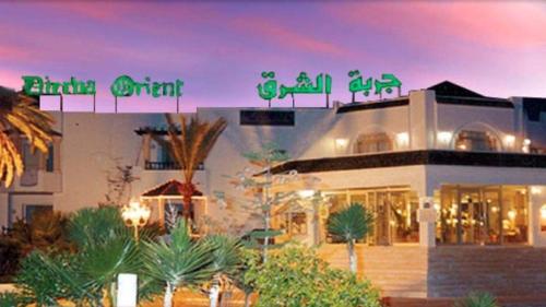 a building with a sign on top of it at Hotel Djerba Orient in Mezraya