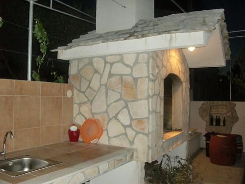 a stone kitchen with a sink and a stone oven at Apartment Marina in Slatine