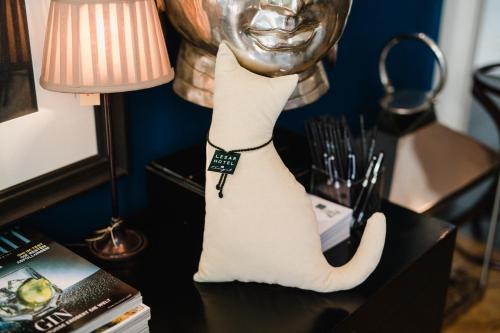 a cat statue sitting on a table next to a lamp at Lesar Hotel Angel - Member of Hip Hotels in Ljubljana