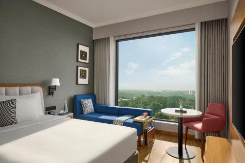 a hotel room with a bed and a large window at Hyatt Place Bhopal in Bhopal