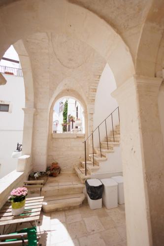 a staircase in a building with a stone archway at Accogliente Dimora in Putignano