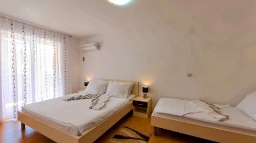 a bedroom with two beds and a window at Apartmani Daria in Medulin