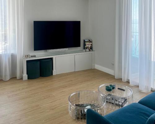 a living room with a flat screen tv on a stand at Hotel Eden Palace au Lac in Montreux