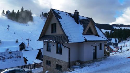 a house with snow on the roof of a mountain at Chata Barvinok in Litmanová