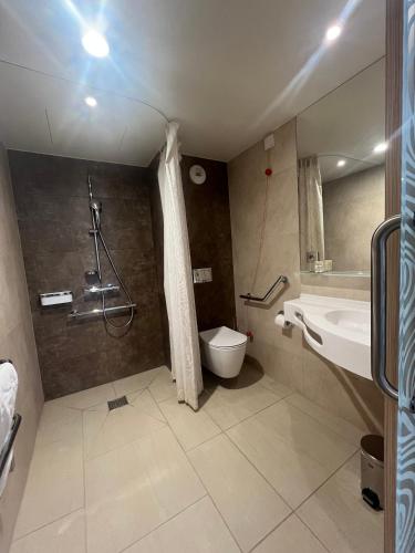 a bathroom with a shower and a sink and a toilet at Appart One Chambéry in Chambéry