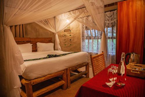 a bedroom with a canopy bed and a table with a table sidx sidx at Kutoka Lodge in Arusha