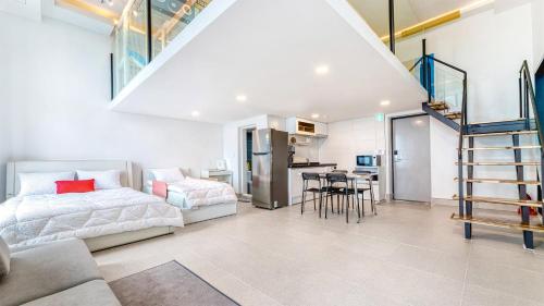 a bedroom with a bed and a table and a kitchen at Goseong Belossi Ayajin Kids Poolvilla in Goseong