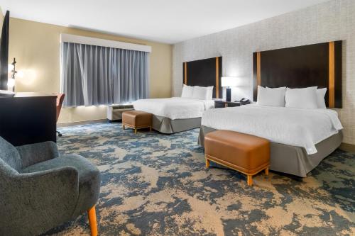 a hotel room with two beds and a chair at Hampton Inn Marion in Marion