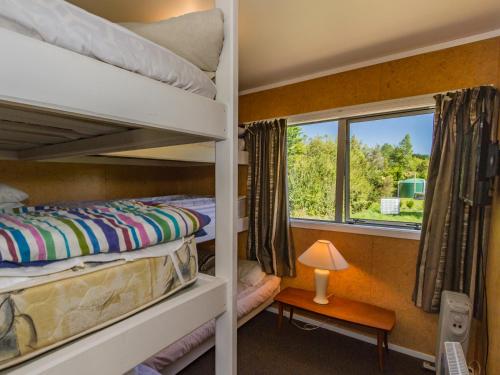 two bunk beds in a room with a window at Sweet Rangataua - Rangataua Bach in Ohakune