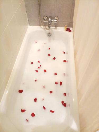 a white bath tub with hearts on the floor at OrientalPalace Hotel in Manama
