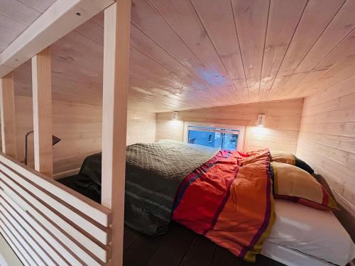 a small room with a bed in a wooden cabin at Tiny House im Almtal in Pettenbach
