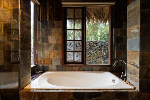 a bath tub in a bathroom with a window at Puluong Qui E Ora in Lũng Tiềm
