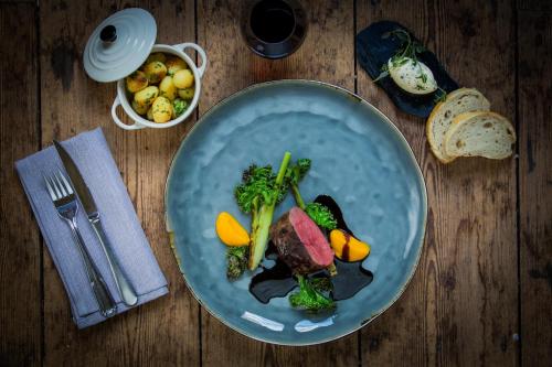 a blue plate of food on a wooden table at Hennickehammars Herrgård in Filipstad