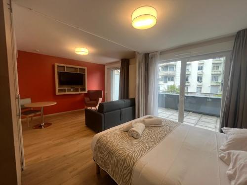 a hotel room with a bed and a large window at Appart One Chambéry in Chambéry