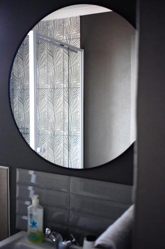 a bathroom mirror with a sink and a window at TAG@12A in Piet Retief