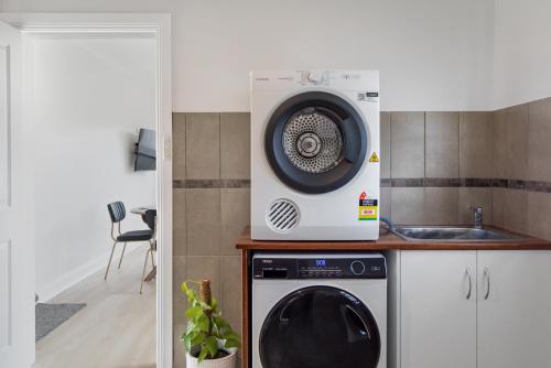 a microwave sitting on top of a washing machine in a kitchen at Wallace Cottage in Mount Gambier