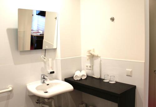 a bathroom with a sink and a mirror at Come IN Hotel in Ingolstadt