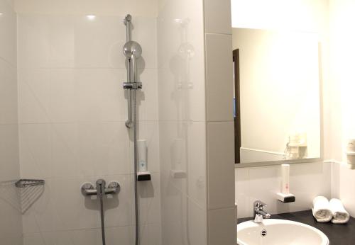 a bathroom with a shower and a sink at Come IN Hotel in Ingolstadt