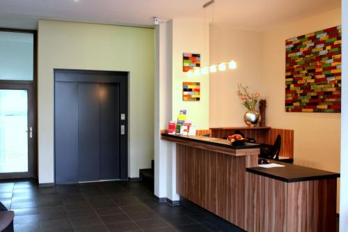 a kitchen with a white counter top and a large mirror at Come IN Hotel in Ingolstadt