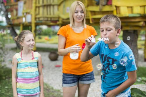 a woman and two children brushing their teeth at Danubius Hotel Marina in Balatonfüred