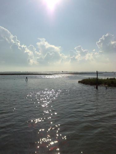 a body of water with the sun reflecting on the water at B&B Al Verde & Mare in Porto Garibaldi