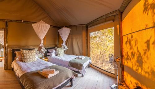 Säng eller sängar i ett rum på Ghoha Hills Savuti Lodge
