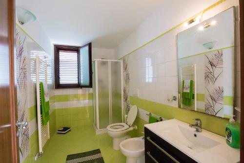 コペルティーノにあるCasa Annetteの緑と白のバスルーム(トイレ、シンク付)