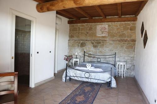 een slaapkamer met een bed en een stenen muur bij Il Borgo Ariccia Resort in Ariccia