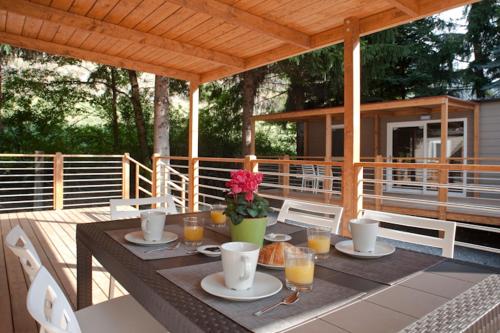 stół z talerzami jedzenia i napojów na patio w obiekcie Gran Bosco Camping & Lodge w mieście Salbertrand