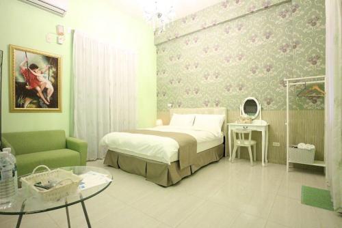 um quarto com uma cama, um sofá e uma mesa em Muses' Fantasy B&B em Taitung City