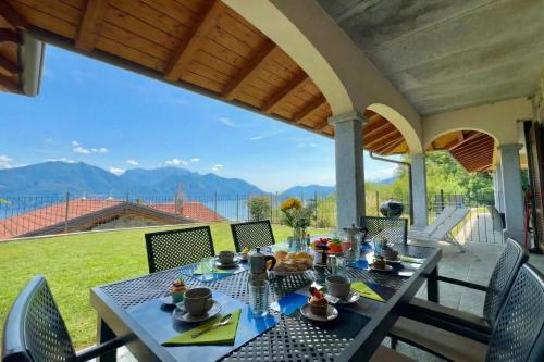 a dining table on a patio with mountains in the background at Villa Aurelia in Plesio