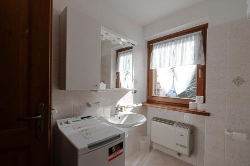 a white bathroom with a sink and a window at Case Gran Paradiso Rhemes Notre Dame in Rhêmes-Notre-Dame