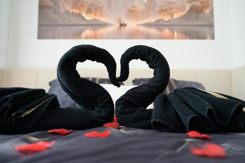 two black swans sitting on top of a bed at Echappée Nocturne in Saint-Privat