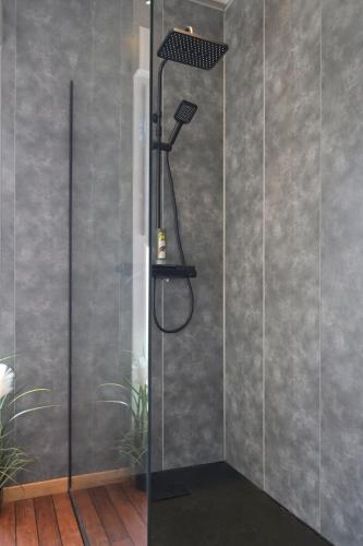 a shower with a shower head in a bathroom at Echappée Nocturne in Saint-Privat