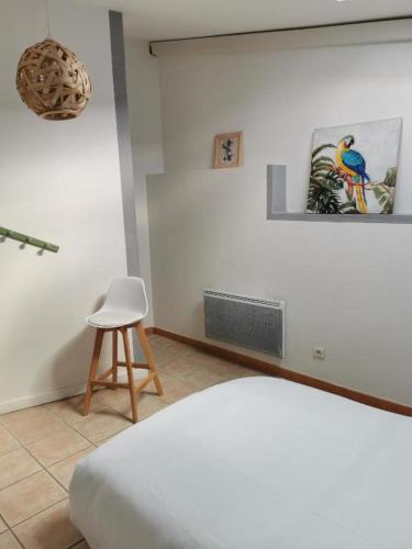 Una habitación blanca con una silla y una cama. en La Provençale, en Valensole