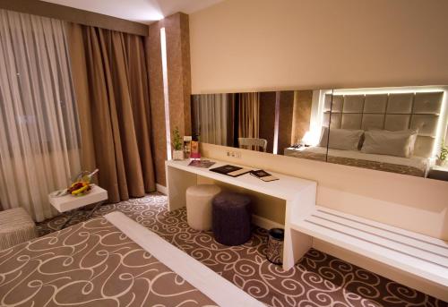 a hotel room with a desk and a large mirror at Grand Hotel Gaziantep in Gaziantep