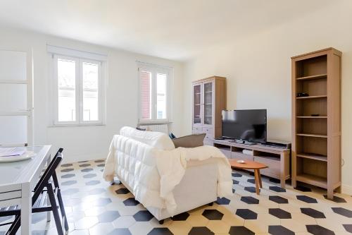 a living room with a white couch and a tv at InnPisaRentals2- Casa dei Cavalieri in Pisa