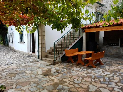 a table and two chairs in front of a building at Casa Dos Santos Alojamento - Guest House in Geres