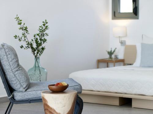 a bedroom with a bed and a chair and a bowl of fruit at Arpathea Villas in Foinikion