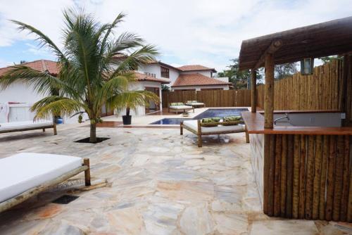 a patio with a table and a palm tree at Villa Ferradura Mar in Búzios