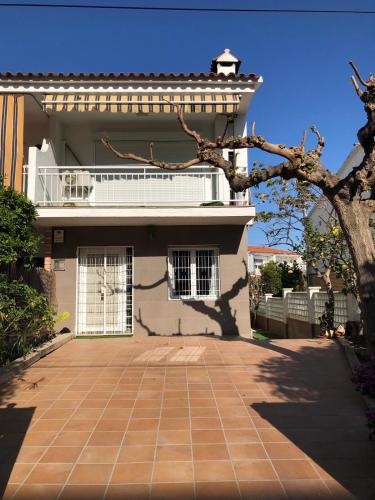 a large white house with a brick driveway at Casa con piscina ideal vacaciones en la playa in Comarruga